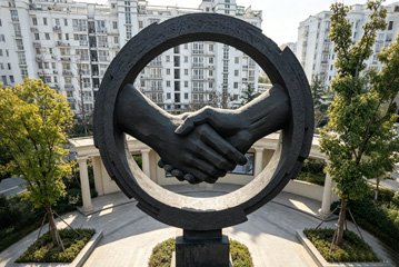 A monumental public art installation by Wensculp symbolizing professional partnership and academic excellence in the bronze casting industry