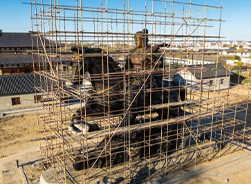 Monumental bronze equestrian statue under installation at a construction site with extensive scaffolding, demonstrating Wensculp's precision engineering, 3D positioning, and structural integrity standards