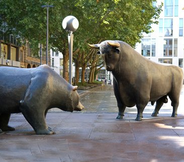 Monumental bronze bull and bear statues in a city plaza demonstrating custom large-scale sculpture solutions for public spaces
