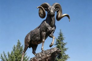 Majestic bronze ram statue on a rock base, illustrating our Farm & Livestock collection for country clubs and golf courses to enhance pastoral charm.