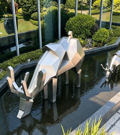 Bespoke modern abstract geometric metal elephant sculpture in a water feature, illustrating our 100% guarantee of successful delivery for landmark municipal projects and corporate landscaping.