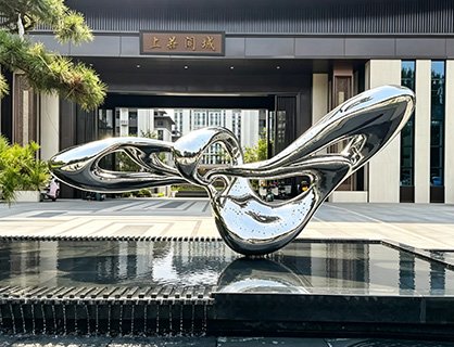 Bespoke mirror-polished abstract stainless steel installation in a water feature, illustrating various Commercial & Real Estate Applications such as Residential Real Estate and Commercial Complexes landmarks.