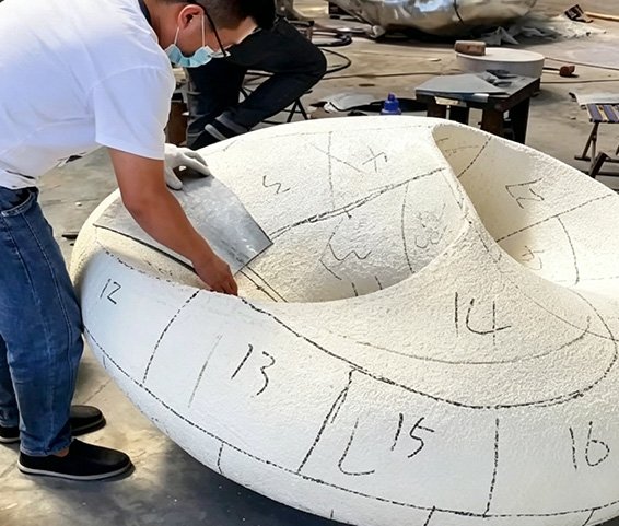Artisans fitting metal plates onto a numbered 3D prototype during The Process of Forged Sculpture Production , illustrating our precision in Lofting & Material Cutting and Digital Modeling & Prototyping .