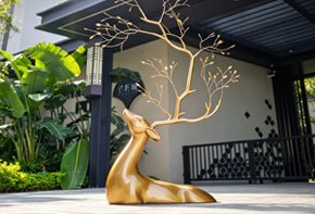 Bespoke bronze deer sculpture in a modern garden setting, achieving a harmonic integration of art and nature for high-end landscape architecture
