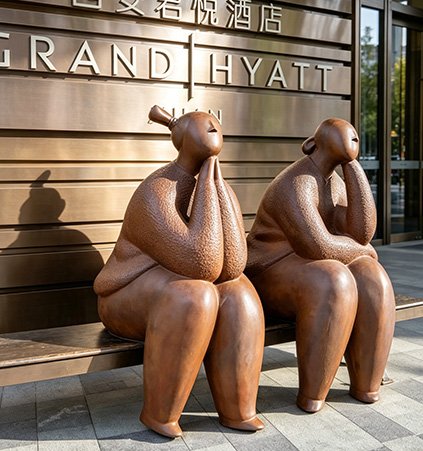 Premium Surface treatment on bronze seated figures at Grand Hyatt, demonstrating antique patination and museum-quality finish for high-end hospitality branding.