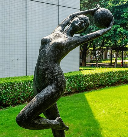 Bronze figurative sculpture of a student athlete in a school garden, designed with strict Safety Standards including rounded contours and anti-topple engineering.