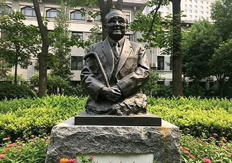 Bespoke bronze bust of a distinguished scholar on a granite base, illustrating our Quality & Compliance Commitment through rigorous stability testing and structural safety reports for schools.