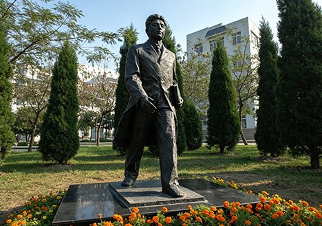 Realistic bronze statue of a walking scholar on campus, illustrating our Serialized Customization Solutions for school anniversaries and academic culture development.