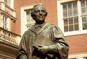 Bronze bust of a distinguished scholar on a university campus, honoring historical achievements and enriching the educational landscape with academic legacy