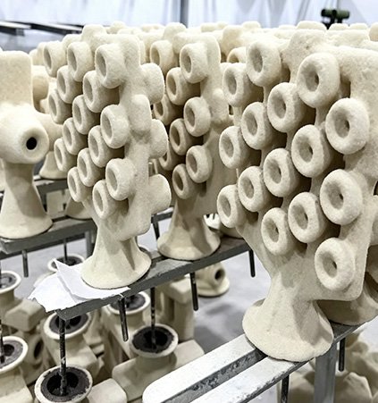 Rows of industrial ceramic shells in the foundry for Portrait Accuracy, illustrating Wensculp's 1:1 scale clay model process and 100% fidelity for custom bronze busts.