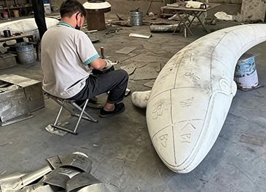 Technician marking and refining a large-scale 3D prototype in the workshop, illustrating Wensculp's professional Communication & Project Management and regular progress updates for clients.