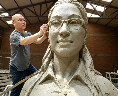 Master sculptor meticulously refining a 1:1 scale realistic clay bust, demonstrating a critical stage in Wensculp's Custom Sculpture Fabrication Workflow for high-fidelity art commissions.