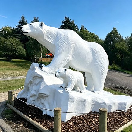 white fiberglass polar bear and cub statue outdoors