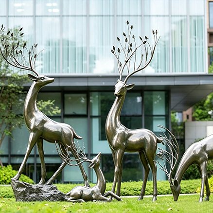 silver metallic fiberglass deer statues in an outdoor courtyard
