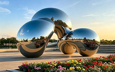 Mirror-polished stainless steel sphere sculpture reflecting the sky