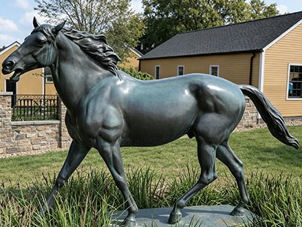 bronze-look galloping fiberglass horse statue outdoors