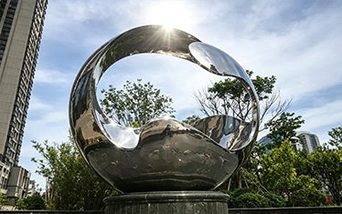 Stainless steel ring and loop sculpture in a garden