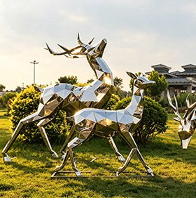 Life-size stainless steel deer and stag sculpture in a garden