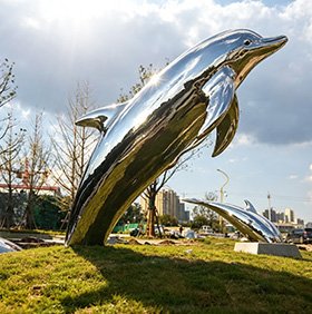 Stainless steel dolphin sculpture leaping outdoors