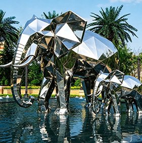 Geometric stainless steel elephant sculpture in a water feature