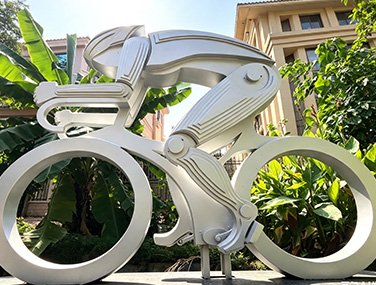 Stainless steel cyclist athlete figure sculpture outdoors