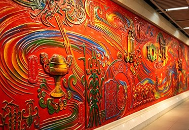 Large bronze relief mural wall in a metro station