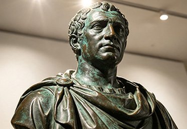 Bronze bust and portrait statue of a historical figure on display