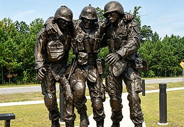 Bronze monument statue of soldiers in a public memorial park