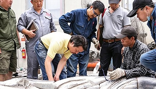Clients and craftsmen reviewing a forged metal piece in the factory