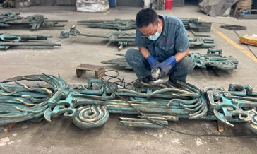 Craftsman working on patinated bronze components at the workshop